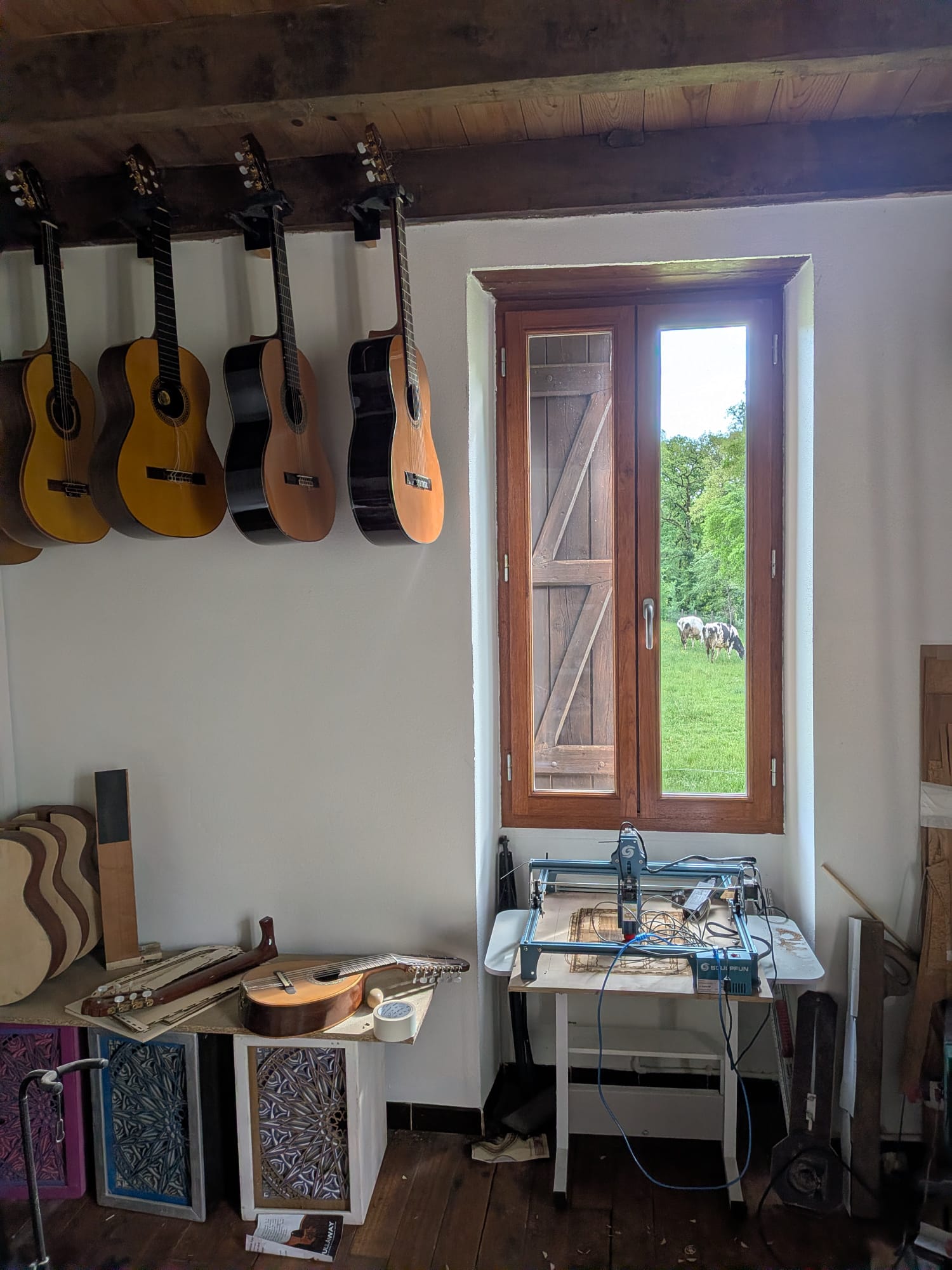 Guitarras clásicas colgadas en el atelier NRG junto a la ventana con vista al prado